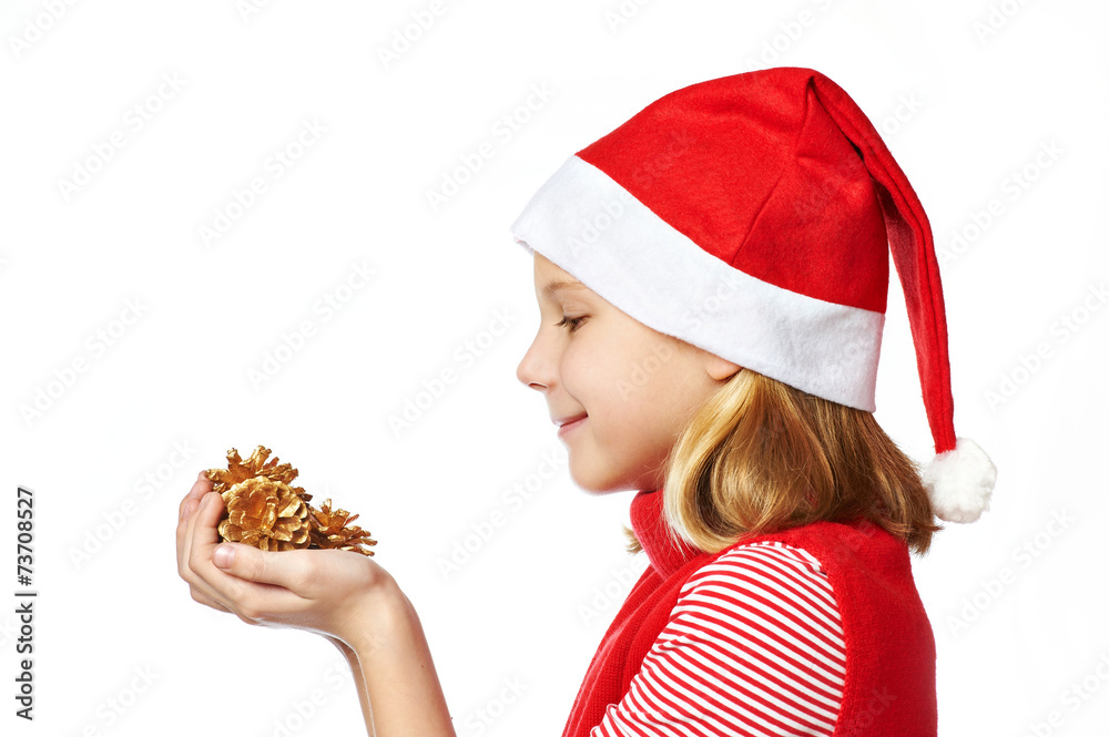 Beautyful girl in red Santa hat with golden pine cones Beautyful girl in red Santa hat with golden pine cones