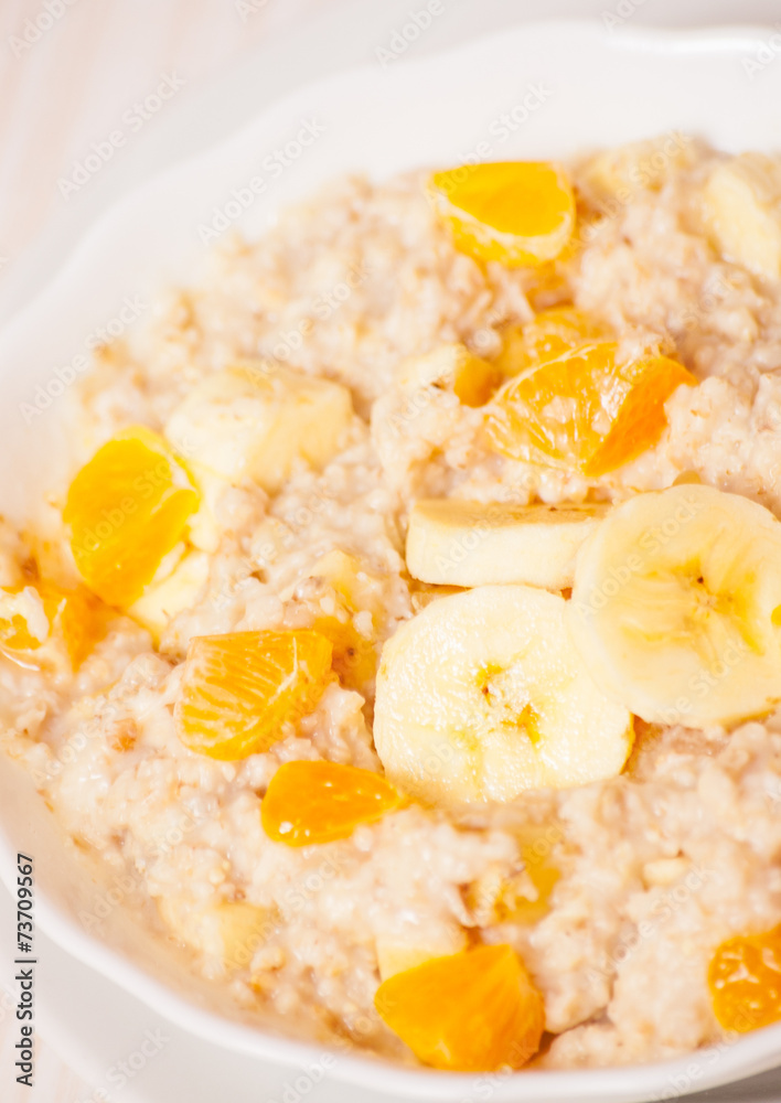 Bowl of oats porridge with banana and tangerine Bowl of oats porridge with banana and tangerine