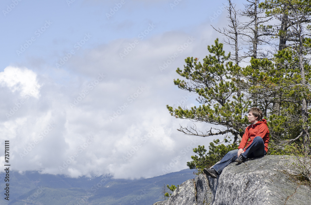 Fototapeta premium Young man enjoying sun on a cliff edge