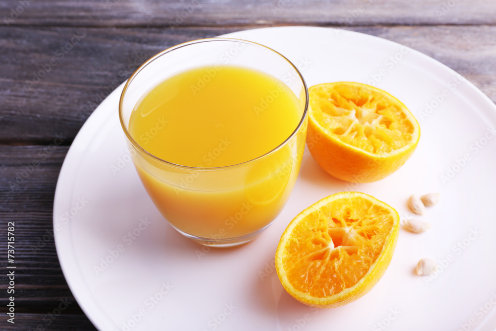 Glass of juice and ripe sweet tangerine on wooden table Glass of juice and ripe sweet tangerine on wooden table