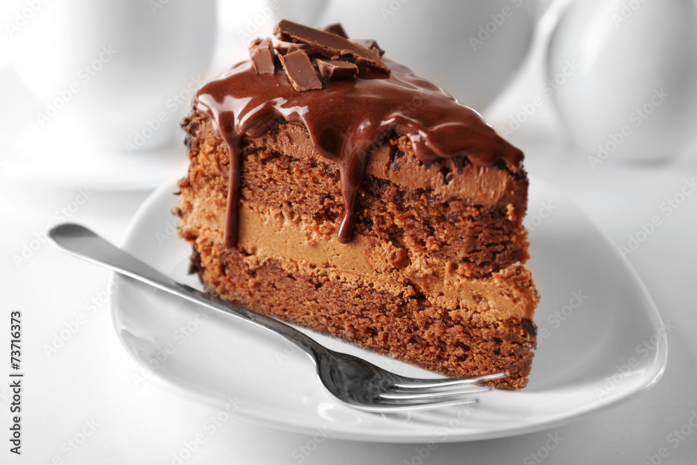Delicious chocolate cake on plate on table on light background Delicious chocolate cake on plate on table on light background