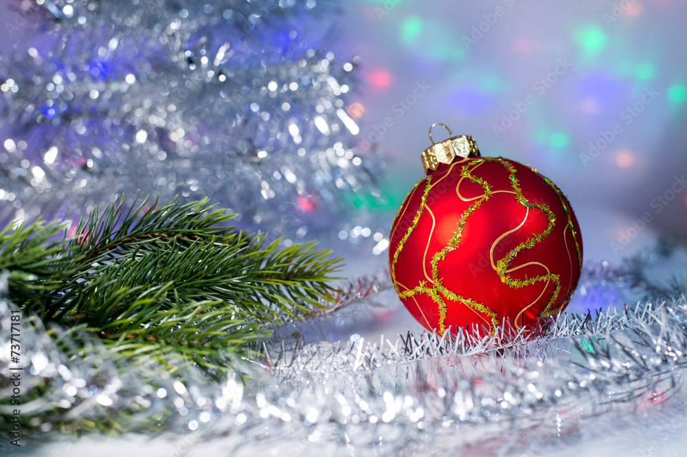 Red Christmas ball and tree branch on the background lights garl Red Christmas ball and tree branch on the background lights garl