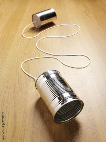 Wooden background with two tin cans for communication