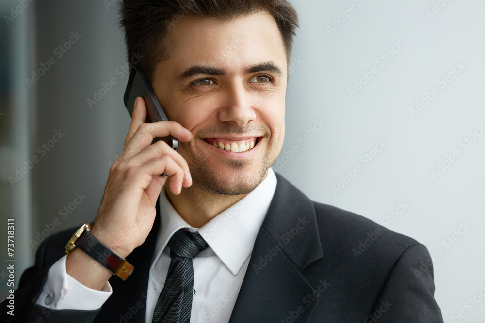 Businessman Talking on the Phone and Smiling Businessman Talking on the Phone and Smiling