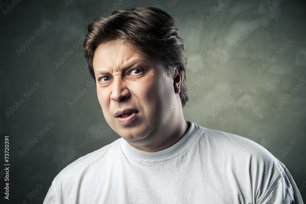 Man with disgusted expression over dark grey