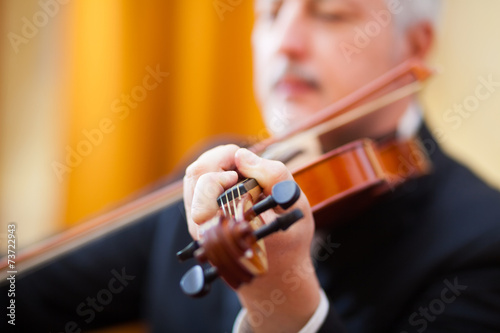 Man playing his violin in a concert hall