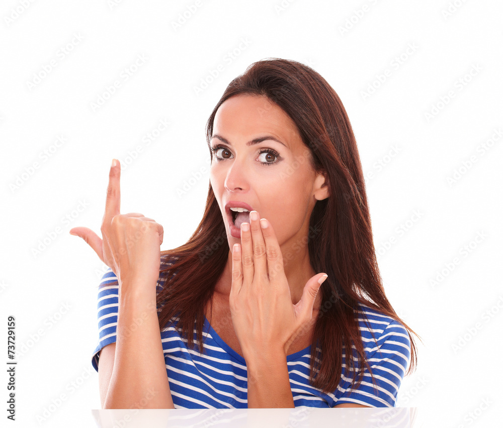 Attractive young woman pointing up to white space Attractive young woman pointing up to white space