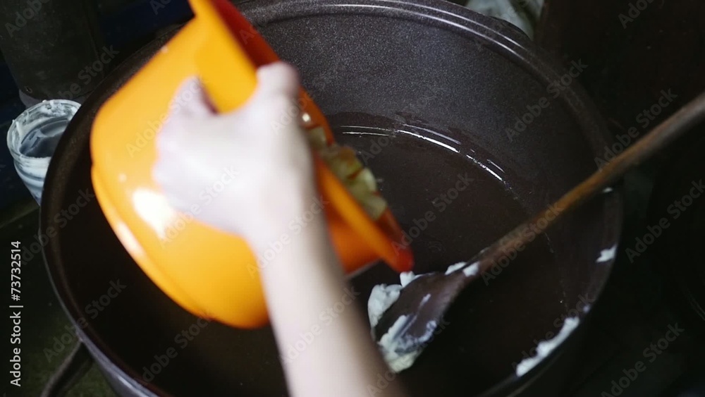 Old butcher throwing meat fat into pot in slow motion Old butcher throwing meat fat into pot in slow motion
