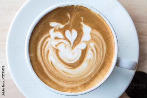 Closeup of a cup of Coffee with latte art on the surface.