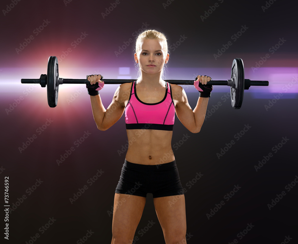 Obraz premium sporty woman exercising with barbell