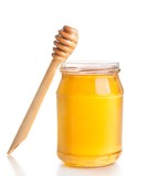 opened honey jar on white background near wooden honey dipper