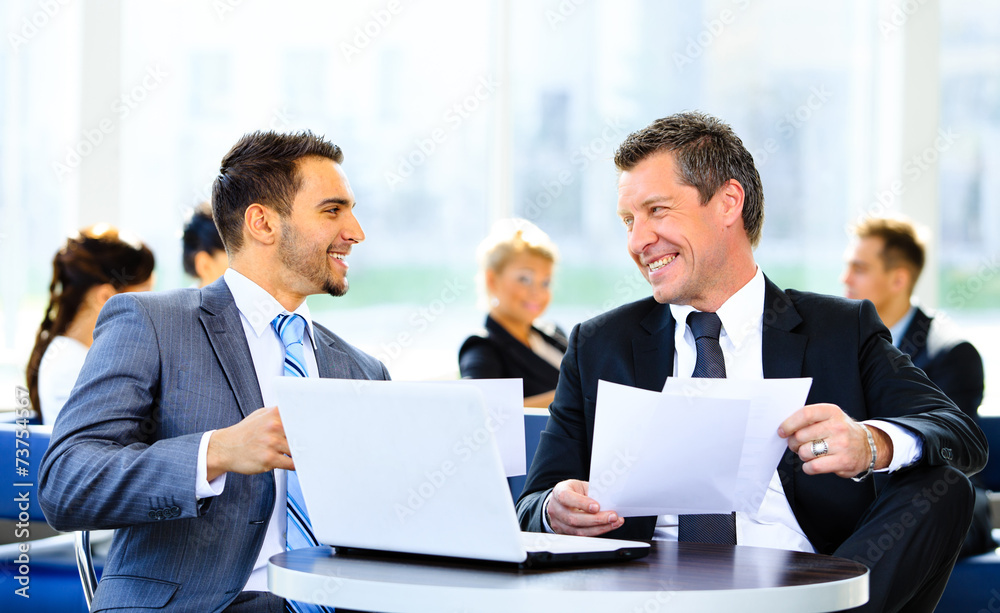 Image of business partners discussing documents Image of business partners discussing documents