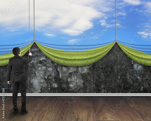 businessman pulling open sky curtain covered old dirty concrete