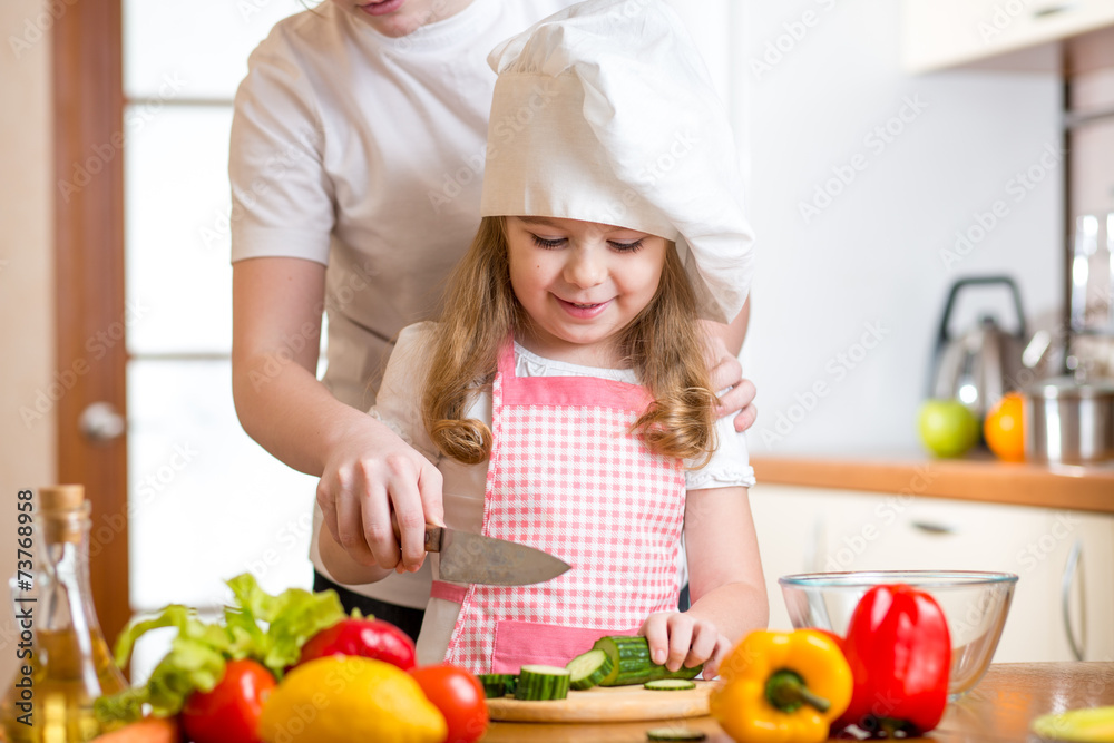 mother and daughter cooking and cutting vegetables on kitchen mother and daughter cooking and cutting vegetables on kitchen