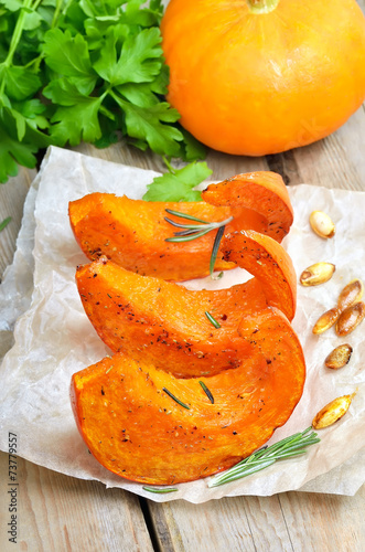 Baked pumpkin slices on rustic table