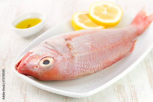 fresh fish with lemon on white dish