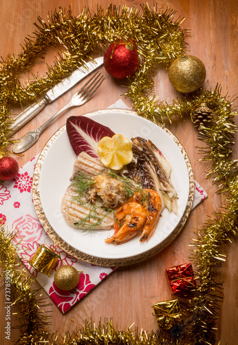 mixed grilled fish with red chicory over christmas table
