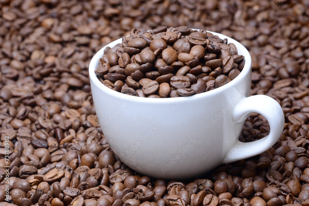 Fototapeta premium cup with coffee grains on a coffee beans background