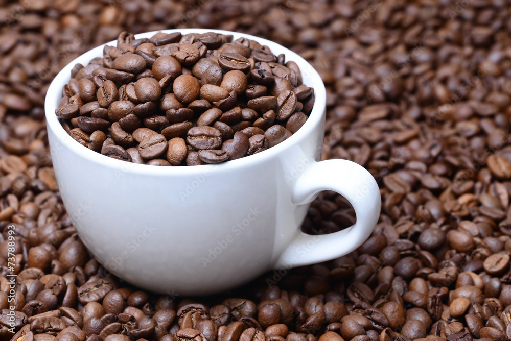 Fototapeta premium cup with coffee grains on a coffee beans background