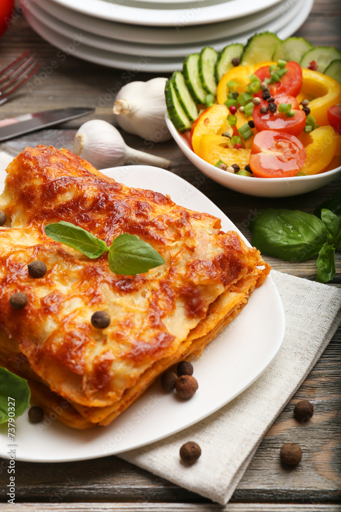 Portion of tasty lasagna on wooden table Portion of tasty lasagna on wooden table