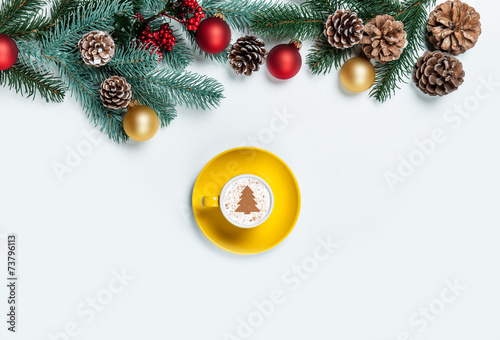 Cup of cappuccino with christmas tree shape on a white table.
