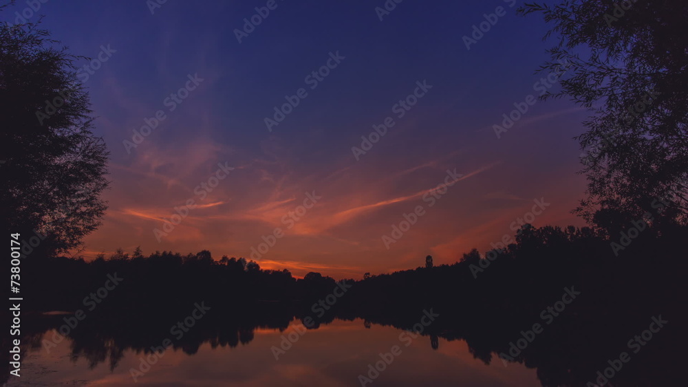 The picturesque sunset (sunrise) above forest near the lake The picturesque sunset (sunrise) above forest near the lake