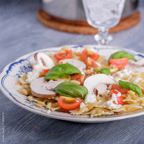 Pasta salad with tomatoes and mushrooms and some basil