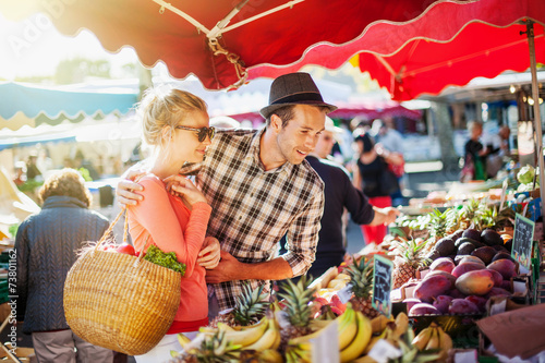 Murais de parede a young couple buying fruits and vegetables at a market