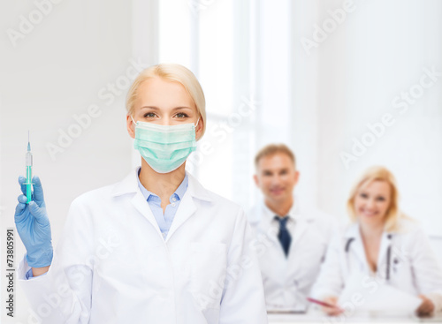 doctor in mask holding syringe with injection