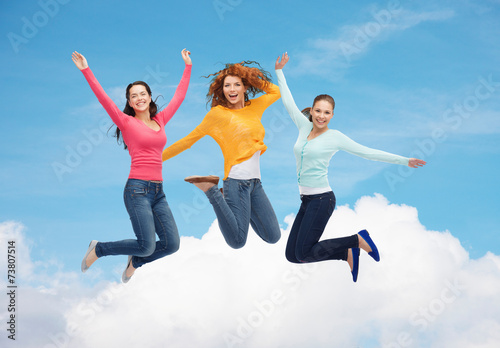 group of smiling young women jumping in air