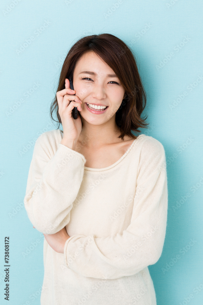 attractive asian woman talking on blue background attractive asian woman talking on blue background