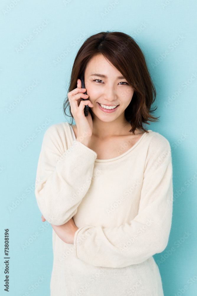 attractive asian woman talking on blue background attractive asian woman talking on blue background