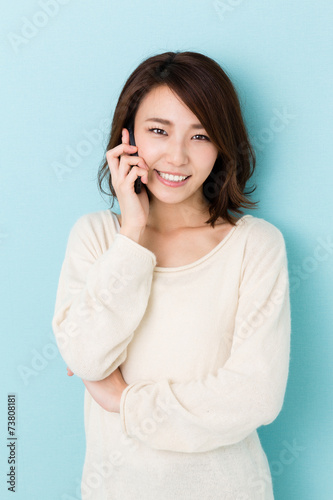 attractive asian woman talking on blue background