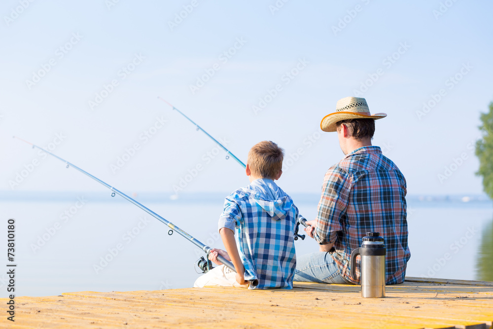 boy and his father fishing togethe