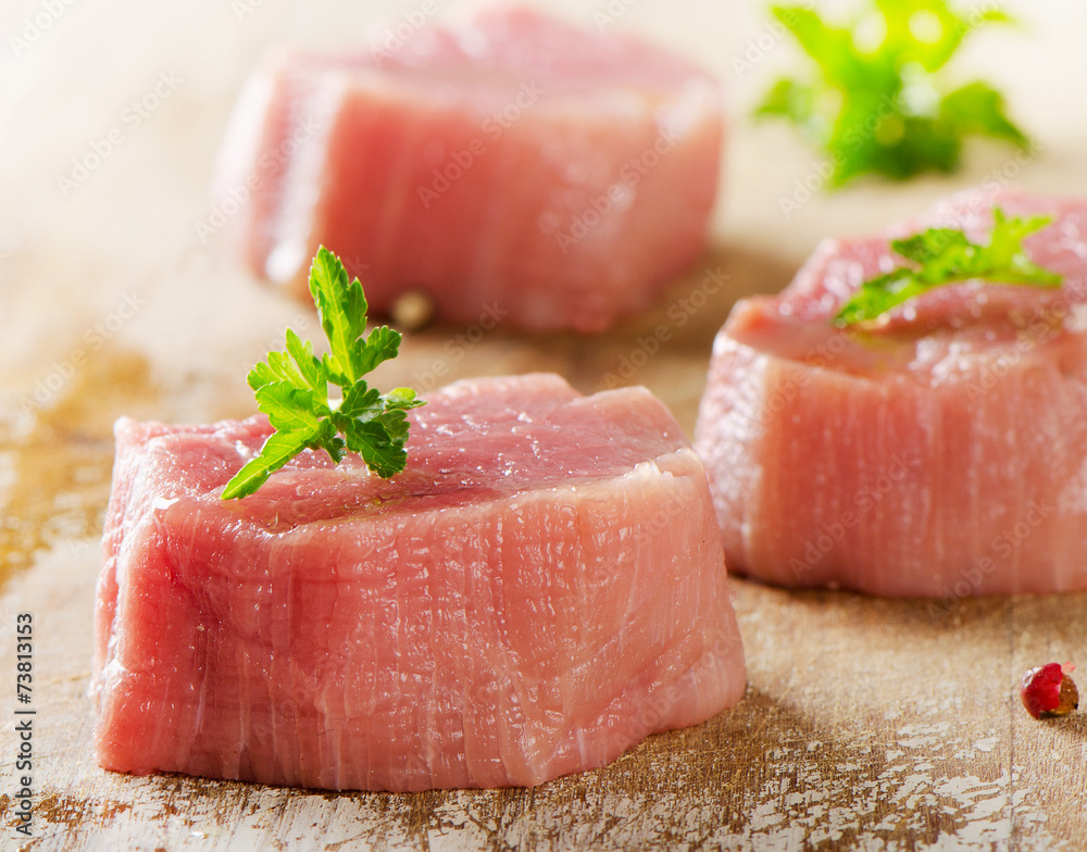 Raw beef with herbs on a wooden background. Raw beef with herbs on a wooden background.