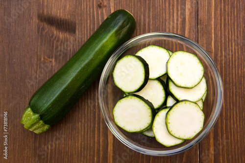 Cuadro en lienzo Zucchini slices on bowl on wooden table top views
