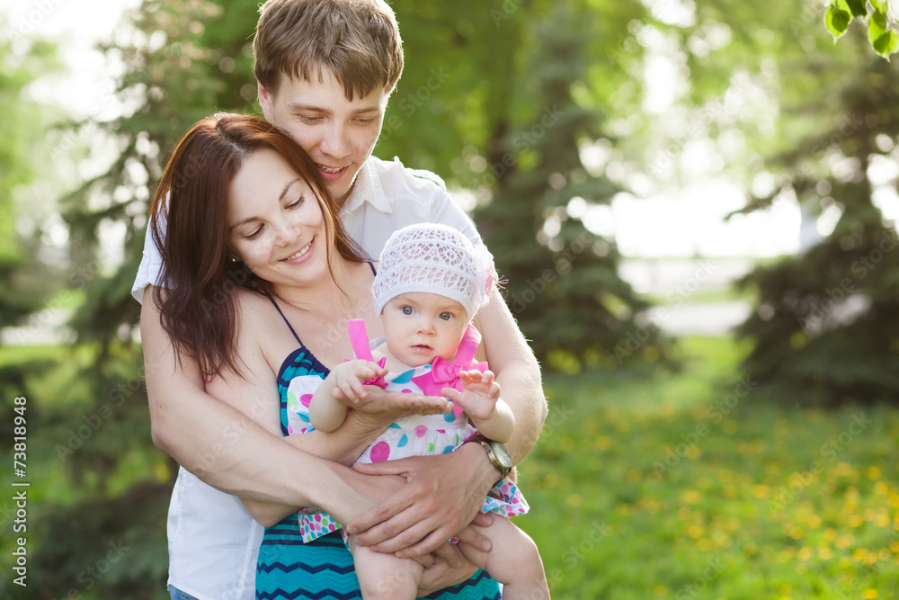 Portrait of young family with baby daughter in summer park Portrait of young family with baby daughter in summer park