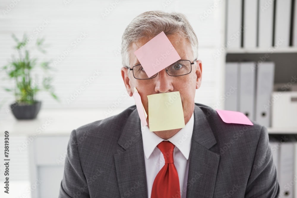Confused businessman with sticky notes on head Confused businessman with sticky notes on head