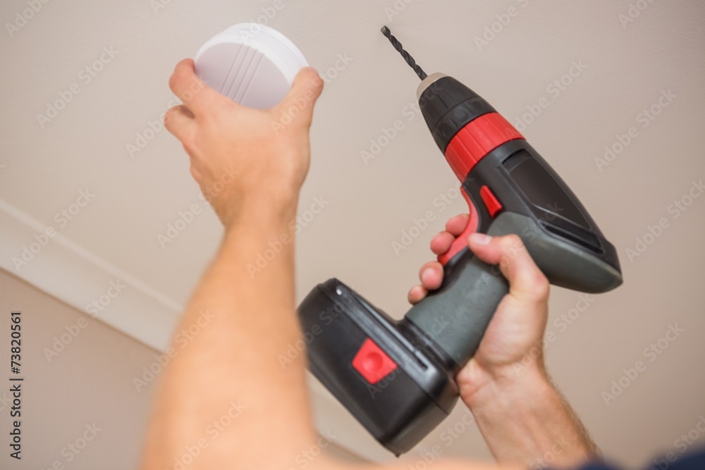 Handyman installing smoke detector - obrazy, fototapety, plakaty 