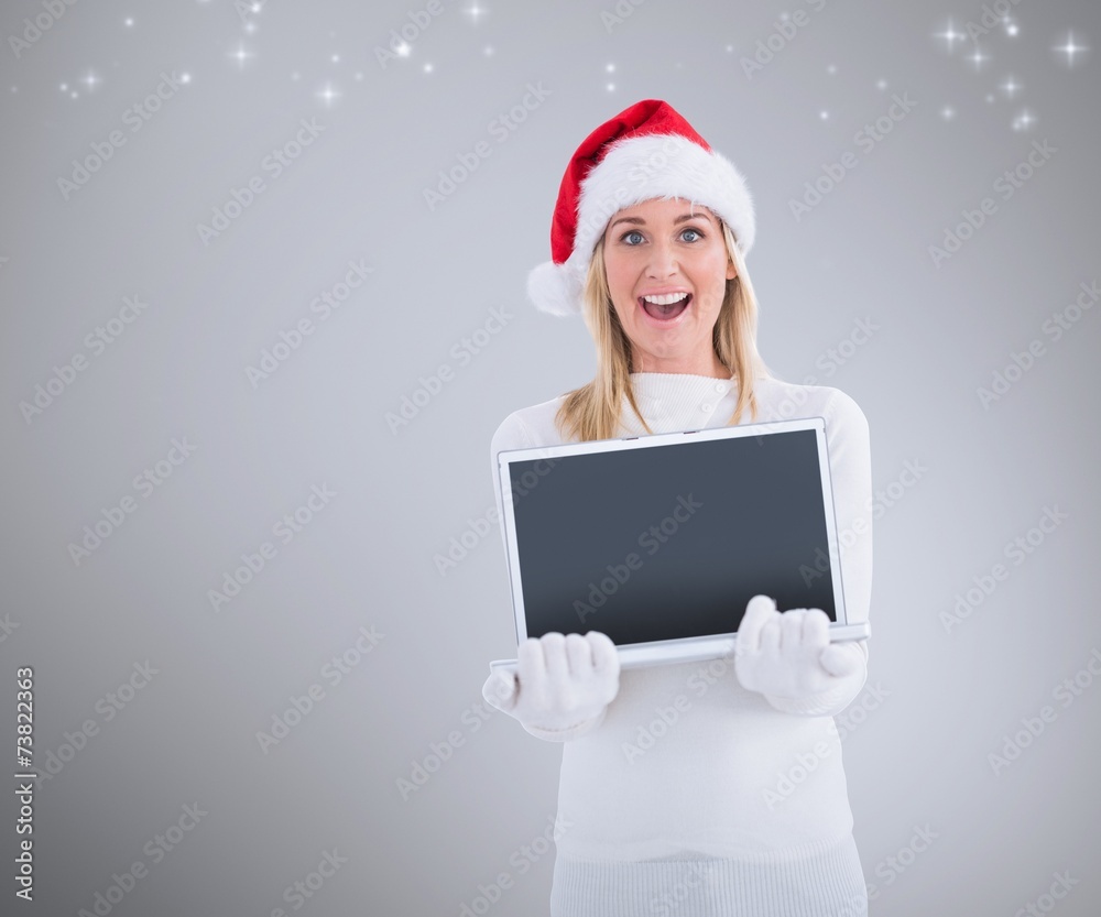 Composite image of festive blonde showing a laptop Composite image of festive blonde showing a laptop