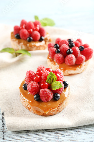 Sweet cakes with berries on table close-up