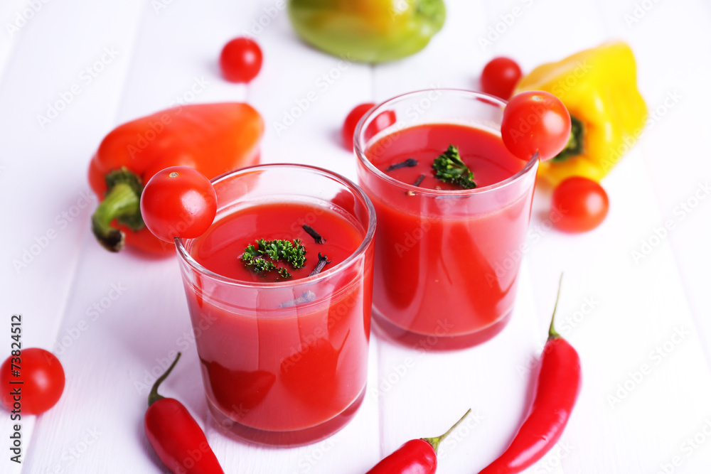 Tomato juice in glasses and fresh vegetables Tomato juice in glasses and fresh vegetables