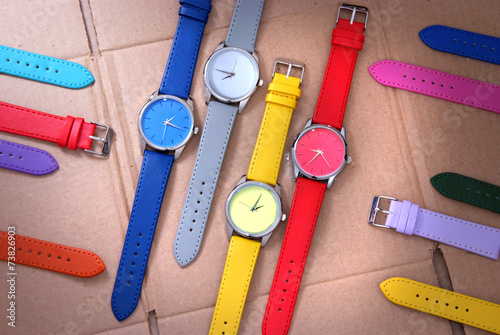 set of colorful watches on cardboard background
