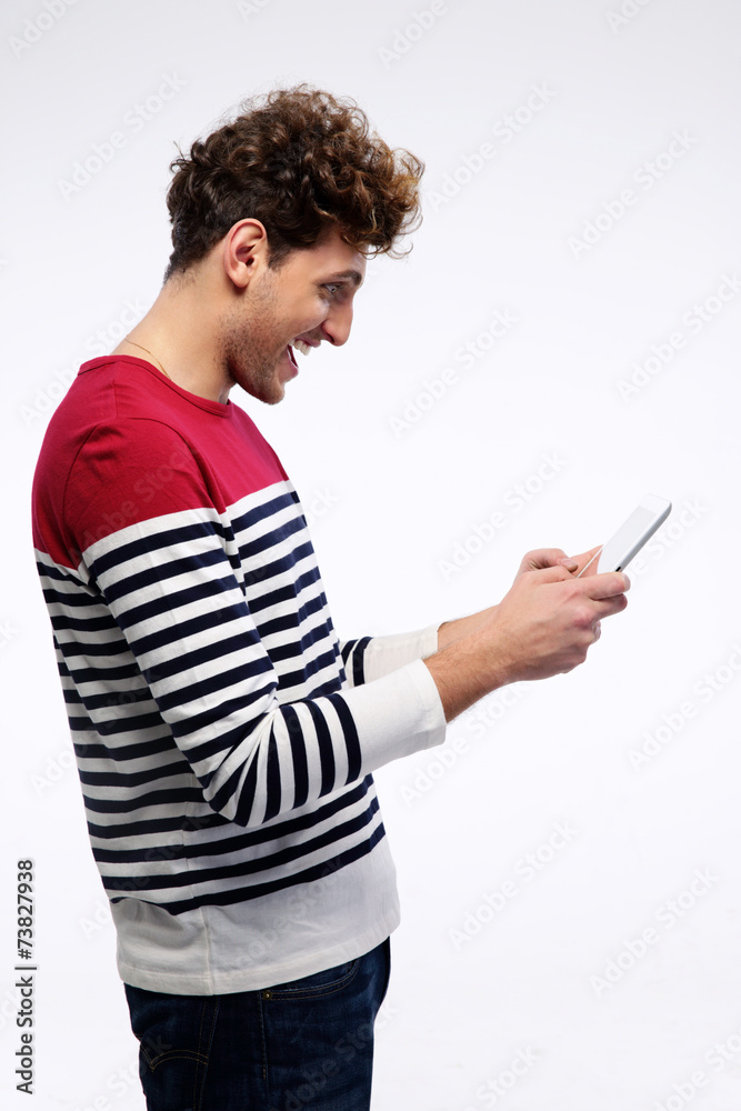 Happy casual man using tablet computer over gray background Happy casual man using tablet computer over gray background