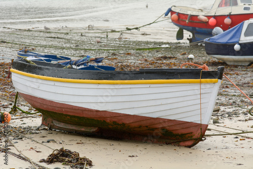 Small fishing boat in harbour at low tide photo