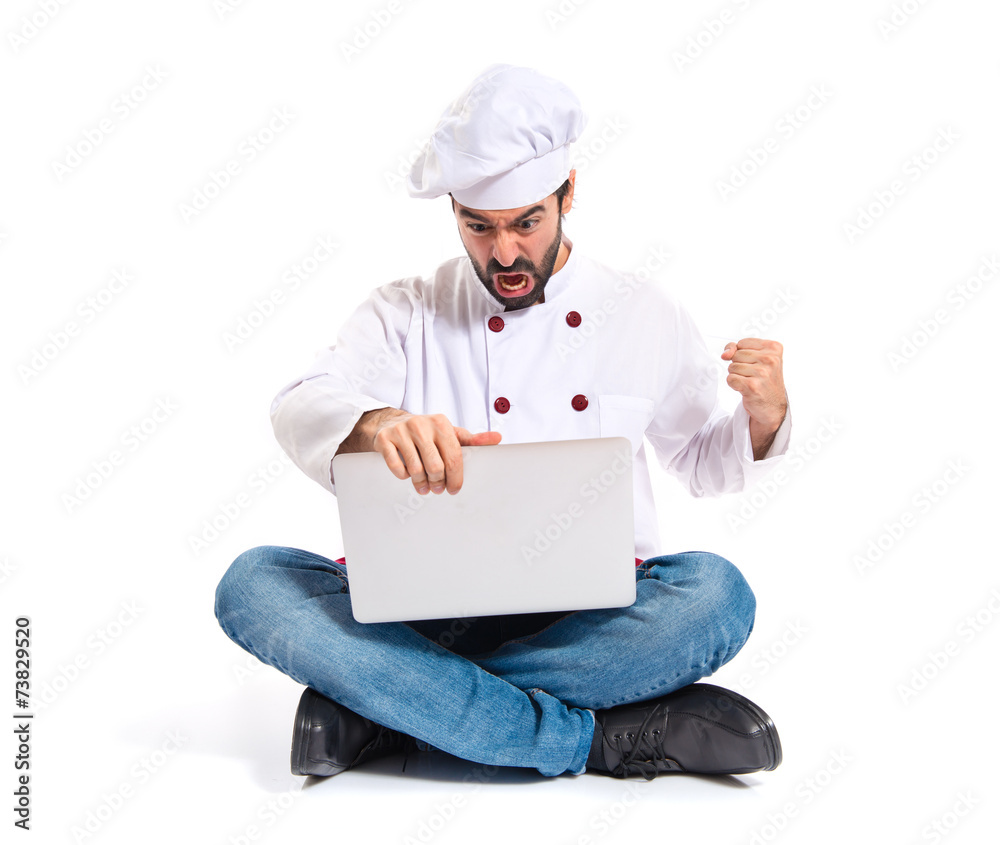 Angry chef with laptop over isolated white background Angry chef with laptop over isolated white background
