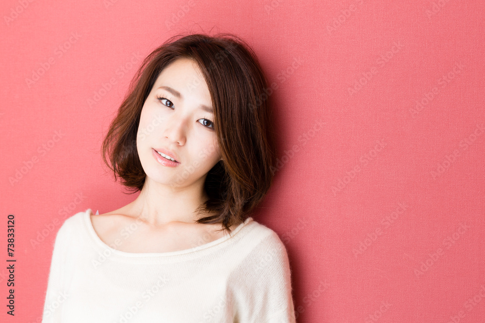 Fototapeta premium attractive asian woman on red background