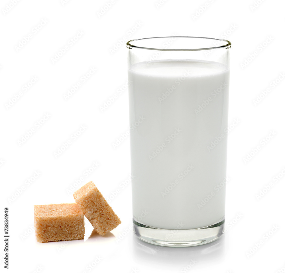 glass of milk and cubes of cane sugar isolated on white backgrou glass of milk and cubes of cane sugar isolated on white backgrou