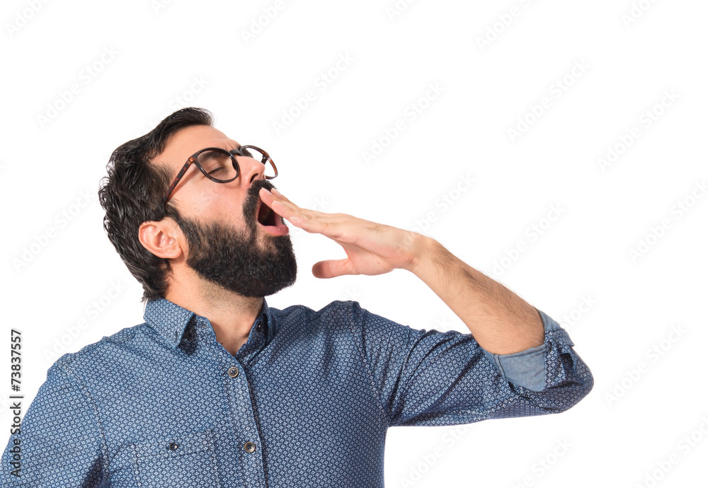 Young hipster man yawning over white background Young hipster man yawning over white background