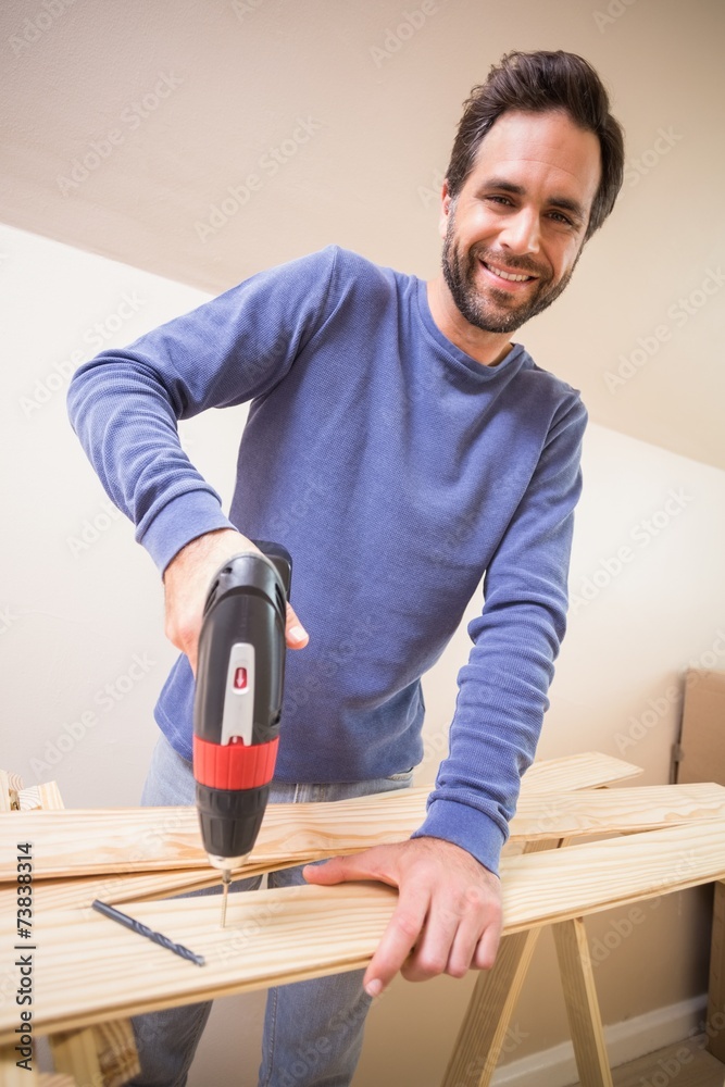 Casual man drilling hole in plank Casual man drilling hole in plank